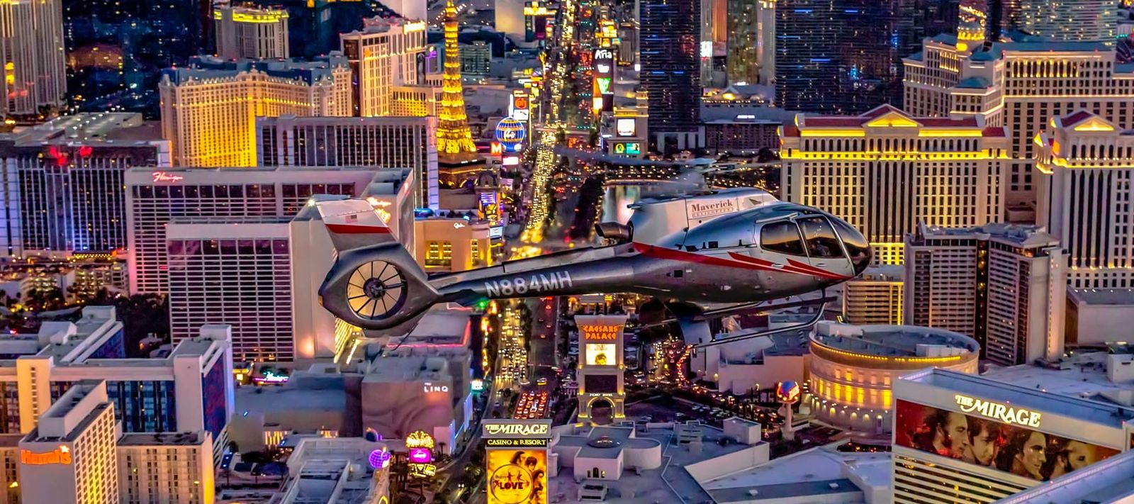 A Maverick helicopter flying over the Las Vegas Strip at night